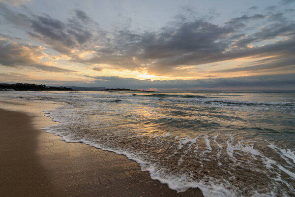 Beautiful morning landscape of the Black Sea coast of Bulgaria with waves at sunrise.