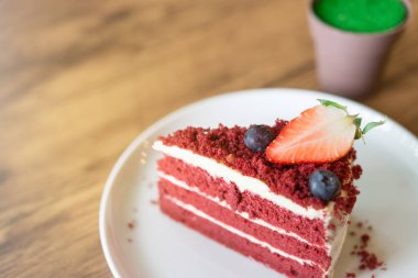 Kafedeki ahşap masada kırmızı kadife peynirli kek..