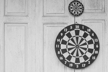 Dart tahtası beyaz ahşap arka planda.