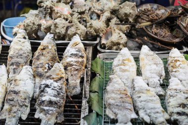 Tuz kabuklu ızgara ızgara ızgara kömür ocağında Tayland sokak yiyecek pazarında satılıyor.