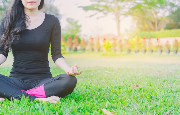 Woman practicing morning meditation in nature at the park. Healt