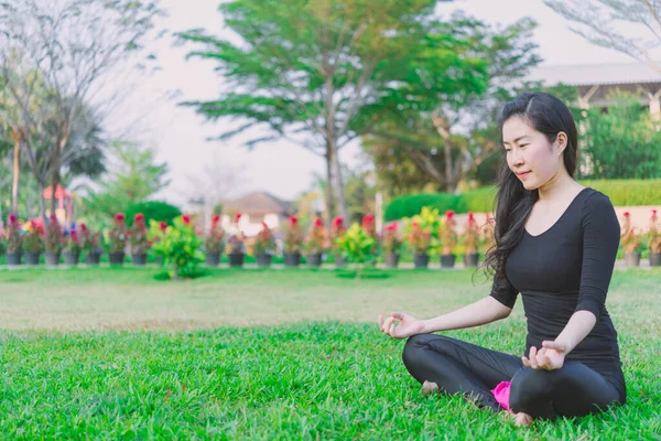 Woman practicing morning meditation in nature at the park. Healt