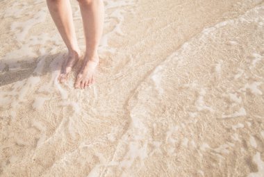 Genç bir kadın sahilde duruyor..