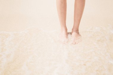 Genç bir kadın sahilde duruyor..