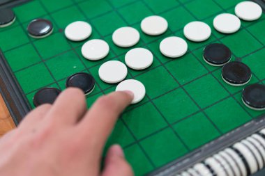 Yeşil Reversi tahtasında (Othello) yakın çekim diskleri, strateji iş konsepti.
