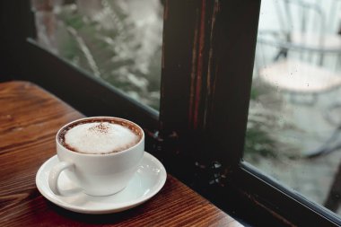 Yağmurlu bir arkaplanda sıcak kahve fincanı