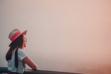 Şapkalı ve güneş gözlüklü genç Asyalı kadın boş beyaz fotokopi alanına bakıyor, yorgun genç bir kadının portresi. Depresyon