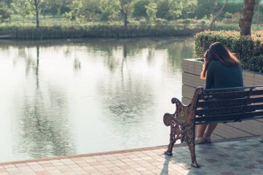 Üzgün, üzgün ve endişeli bir kadın dışarıda yalnız başına oturuyor.