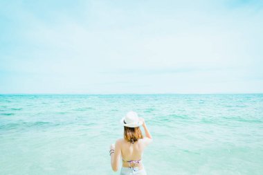 Açık havada, okyanusa bakan güzel bir kadının yaz portresi.