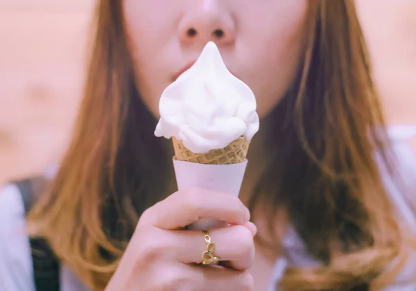 Woman eating ice cream on a Cone.