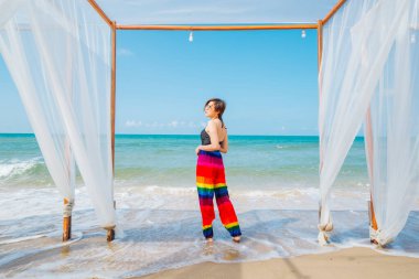 Plajın tadını çıkaran bir kadın. Yazın tropik deniz sahillerinde neşe içinde dinleniyor.