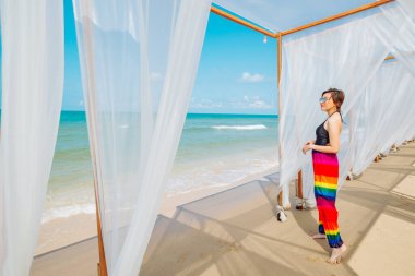 Plajın tadını çıkaran bir kadın. Yazın tropik deniz sahillerinde neşe içinde dinleniyor.