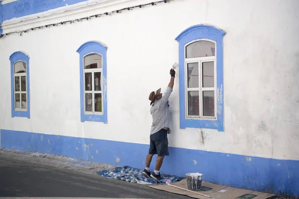 Ein Mann bemalt sein Haus — Stockfoto