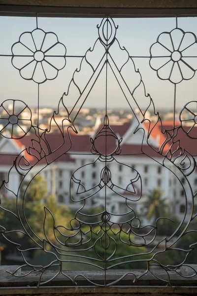 Una ventana con un buddha en la vista desde la parte superior del arco patuxai — Foto de Stock