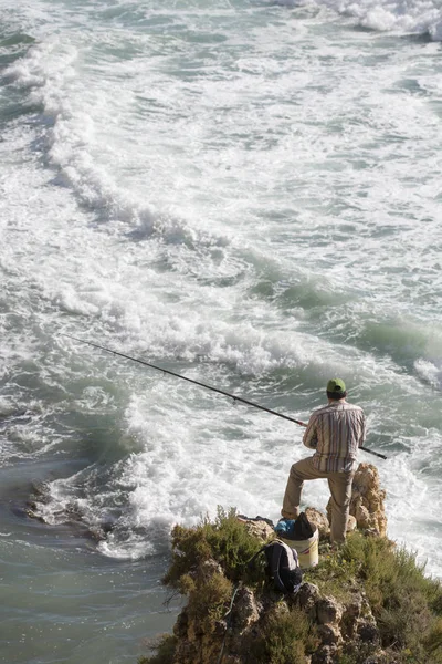 Ein Fischer in der Landschaft an den Felsen — Stockfoto