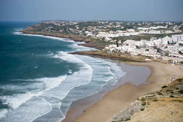 La spiaggia con il villaggio di Luz in Portogallo — Foto Stock
