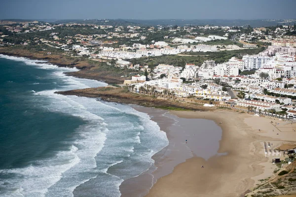 La spiaggia con il villaggio di Luz in Portogallo — Foto Stock