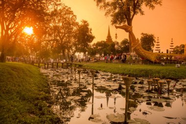 Geleneksel bir tekne ve Tayland 'daki Sukhothai Provinz Sukhothai' deki tarihi parktaki Loy Krathong Festivali 'nde bir tapınak stupası. Tayland, Sukhothai, Kasım 2019
