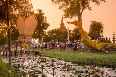 Geleneksel bir tekne ve Tayland 'daki Sukhothai Provinz Sukhothai' deki tarihi parktaki Loy Krathong Festivali 'nde bir tapınak stupası. Tayland, Sukhothai, Kasım 2019