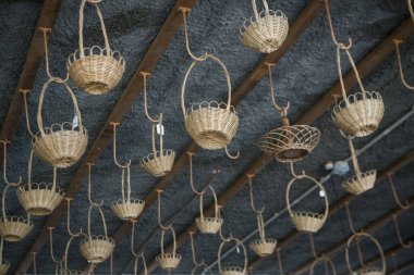 Portekiz 'in Madeira Adası' ndaki Madeira Adası 'nın doğusundaki Camacha kasabasındaki Arema Kafe Relogio Reklam Dükkanı' nda sepet dokuma işi. Portekiz, Madeira, Nisan 2018