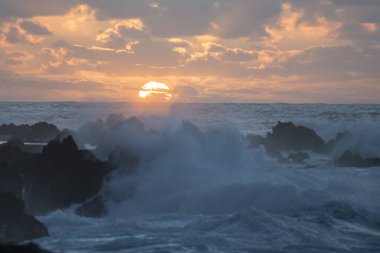 Portekiz 'in Atlantik Okyanusu' ndaki Madeira Adası 'ndaki Porto Moniz kasabasında gün batımında dalgalar ve rüzgar. Madeira, Porto Moniz, Nisan 2018