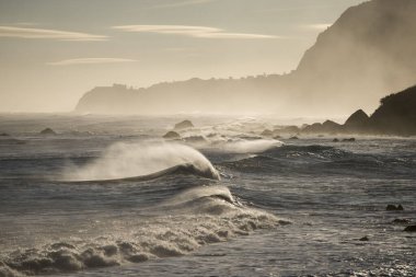 Portekiz 'in Atlantik Okyanusu' ndaki Madeira Adası 'ndaki Porto Moniz ve Ribeira da Janela kasabaları arasında dalgalar ve rüzgar vardır. Madeira, Porto Moniz, Nisan 2018