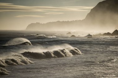 Portekiz 'in Atlantik Okyanusu' ndaki Madeira Adası 'ndaki Porto Moniz ve Ribeira da Janela kasabaları arasında dalgalar ve rüzgar vardır. Madeira, Porto Moniz, Nisan 2018