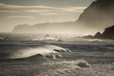 Portekiz 'in Atlantik Okyanusu' ndaki Madeira Adası 'ndaki Porto Moniz ve Ribeira da Janela kasabaları arasında dalgalar ve rüzgar vardır. Madeira, Porto Moniz, Nisan 2018