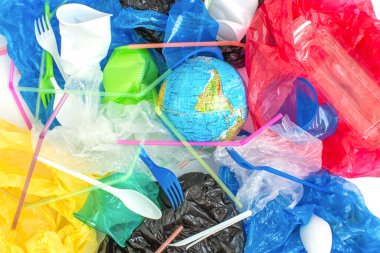 Tek kullanımlık plastik kaplar, plastik torbalar ve küre. Düz yerde, üst tarafta. Ekoloji problemi. Çevre kirliliği.