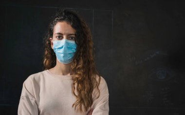 Coronavirus. Korunaklı yüz maskesi takan genç bir kadın..