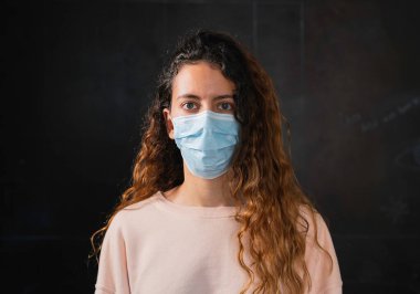Coronavirus. Koronavirüse karşı koruyucu yüz maskesi takan bir genç..