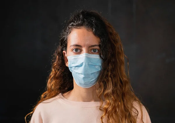 Coronavirus. Koronavirüse karşı koruma maskesi takan genç bir kadın..