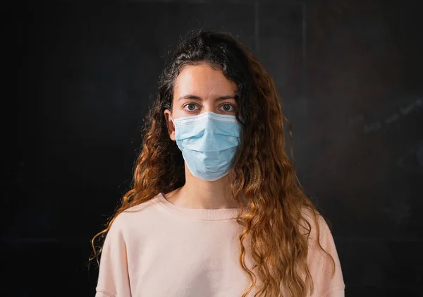 Coronavirus. Koronavirüse karşı koruyucu yüz maskesi takan bir genç..