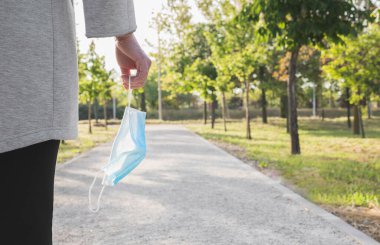 Sosyal mesafe. Elinde koruyucu bir maskeyle parkta yürüyen bekar bir kadın. Coronavirus salgınını sona erdiriyorum. Coronavirus cihazları. Sosyal uzaklık. Salgınlara karşı koruma
