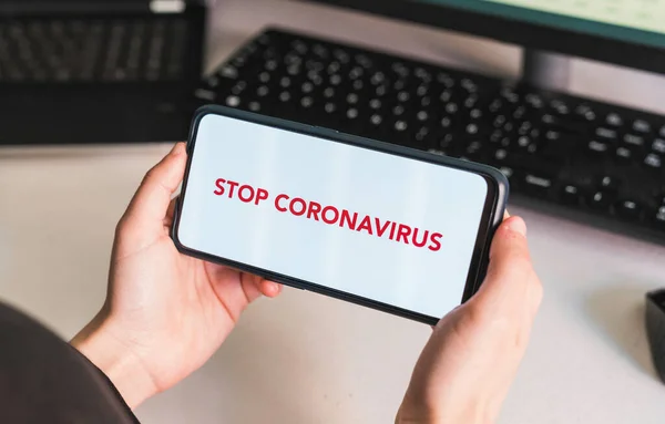 Stop coronavirus. Put your message on the phone. Hands of a woman holding a mobile phone with a blank screen to put a text message or advertising content. Social distance. Coronavirus devices. Social distancing. Protection against pandemics