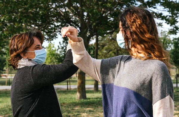 Sosyal mesafe. Dirsek darbesi. Coronavirus 'un yayılmasını önlemek için yeni bir roman. Anne ve kızı birbirlerine el sallıyorlar, dirseklerini çarpıyorlar çünkü koronavirüs yüzünden sarılamıyorlar. Salgın. Coronavirus aygıtları
