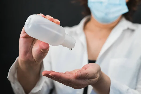 Ellerini nasıl yıkayacağını hijyenik bir şekilde öğretiyor. Ellerini dezenfektan jeliyle yıka. Dezenfektan jeli. Ellerini yıka. Alkol dezenfektanı. Doktor bir maskeyle korunuyor. Coronavirüs.