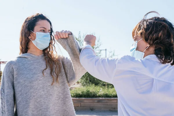 Social distance. Elbow strike. New novel greeting to prevent the spread of the coronavirus. Waving at each other by hitting elbows. Coronavirus. End of the pandemic. Social distancing.