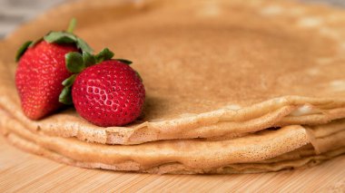 Lezzetli tatlı krepler, ahşap arka planda kırmızı çilekli krepler. Boşluğu kopyala