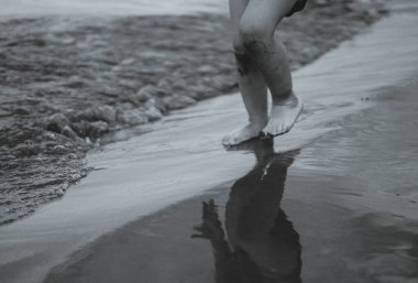 Çocukların ayakları nehir kıyısında koşuyor.