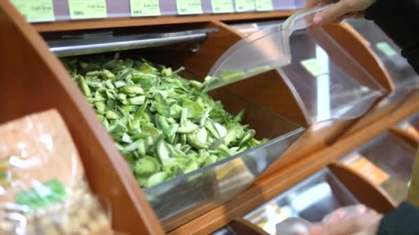 Жіноча рука купує сушені зелені фрукти Помело вагою в супермаркеті . — стокове відео