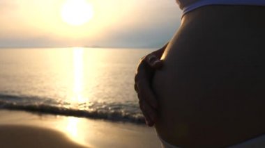 Sunrise 'da plajda dinlenen hamile bir kadının karnı kapanıyor..