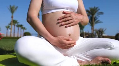 Dışarıda yoga yapan hamile bir kadın. Sağlıklı Hamilelik Konsepti.