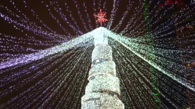 Şehirde gece vakti aydınlatılan Noel ağacı. Tatil zamanı.