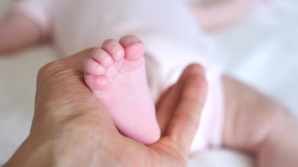 Die Hand des Vaters hält einen winzigen Fuß des Neugeborenen. Nahaufnahme. — Stockvideo