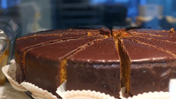 Szekrény csokoládé torta kijelzőn pékségben vagy kávézóban. — Stock videók