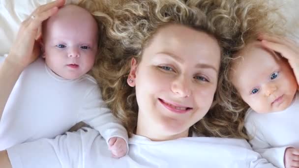 La joven madre y sus bebés sonriendo ante la cámara. Feliz Concepto de Maternidad . — Vídeo de stock