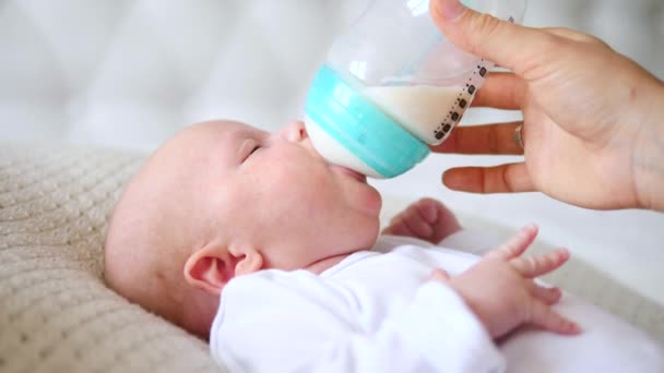 Concetto di alimentazione artificiale. Bambino che beve la formula dalla bottiglia . — Video Stock