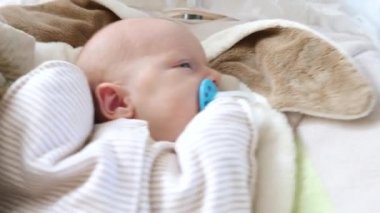 Sevimli yeni doğmuş bebek Aptalla Uyuyor ve sallanıyor.