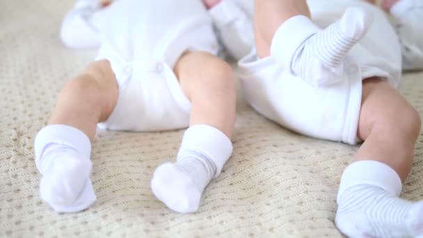 Voeten van twee maanden oude baby 's dragen sokken liggend op bed. Tweelingen. — Stockvideo